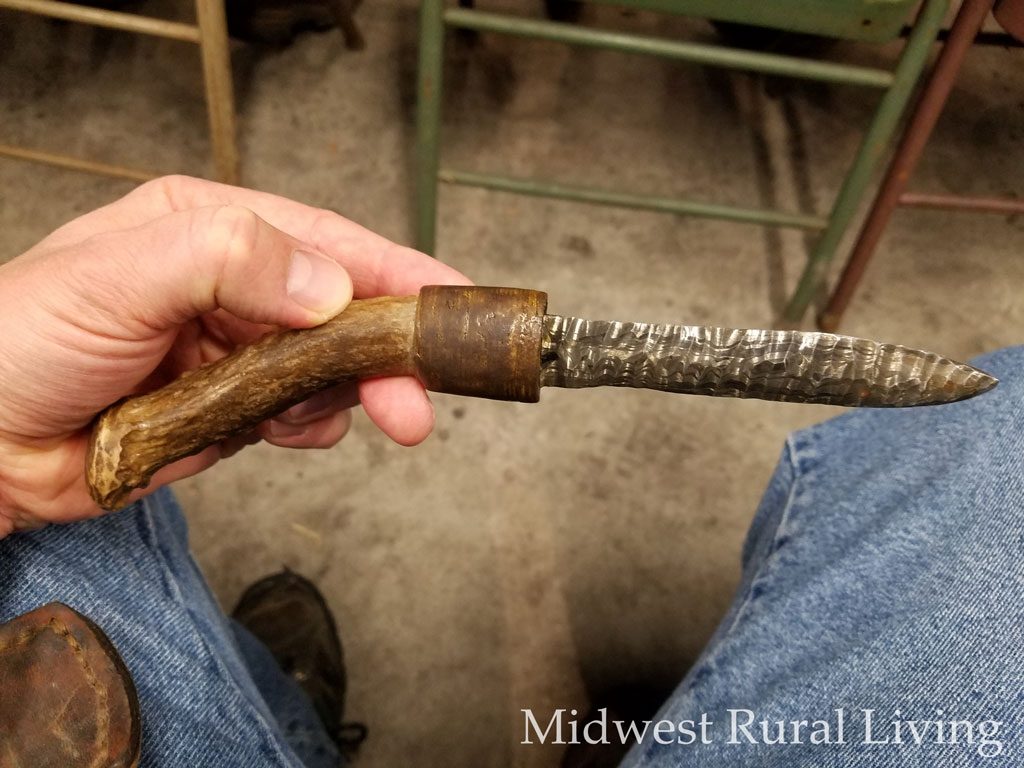 The demonstrator was showing us a Damascus knife he had made previously. The knife was left with a rough and uneven surface look like a flint knife. The handle is made from the base of a deer antler.